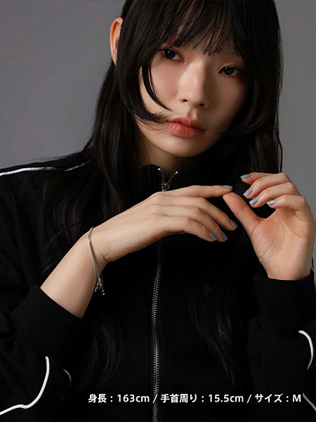 黒いジャージスタイルの女性がシルバーチェーンブレスレットを着けた着用写真。