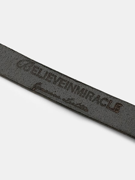 ベルト裏にBELIEVEINMIRACLEとGenuine Leatherの刻印が入ったレザー部分の画像。