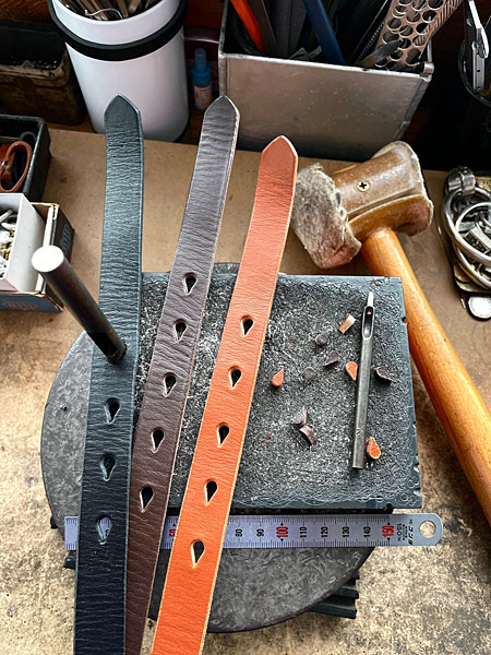 BLACK、DARK BROWN、BROWNの3色のレザーベルトに穴をあけている制作途中の画像。
