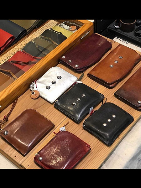 シルバーコンチョをカスタムした使い込んだウォレットが並び、経年変化がわかる店頭ディスプレイ画像。