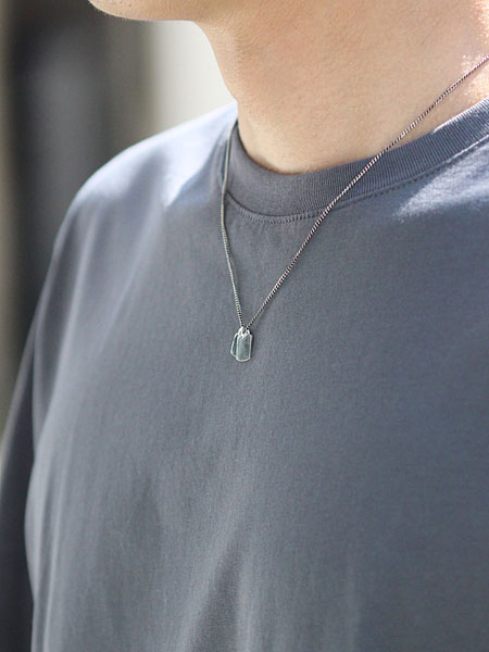 ネックレスをシンプルなTシャツに合わせた男性の着用画像。