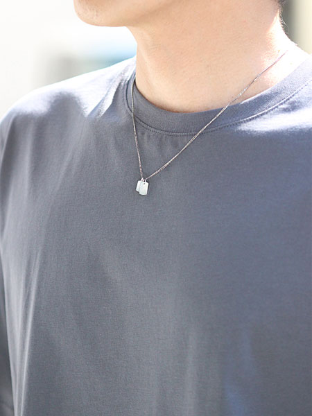 ネックレスをシンプルなTシャツに合わせた男性の着用画像。