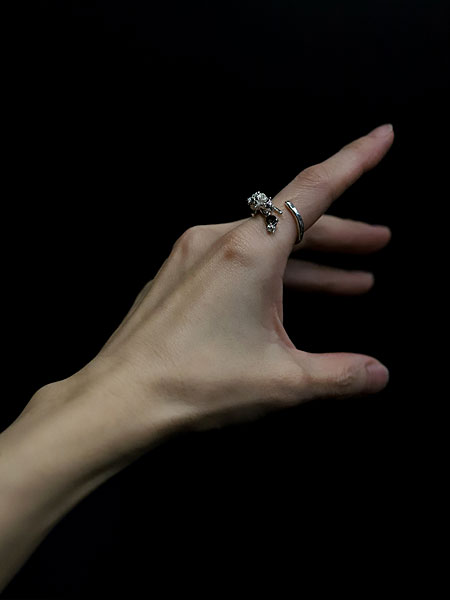 花束を背負ったネコが人差し指にしがみつくように見える、スモーキークォーツ付きリングの女性着用アップ画像。