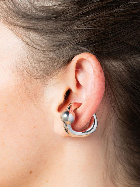 女性が耳にCurl Silver イヤーカフをつけた着用画像。