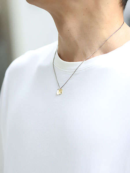 シンプルなTシャツに合わせた男性の着用画像。