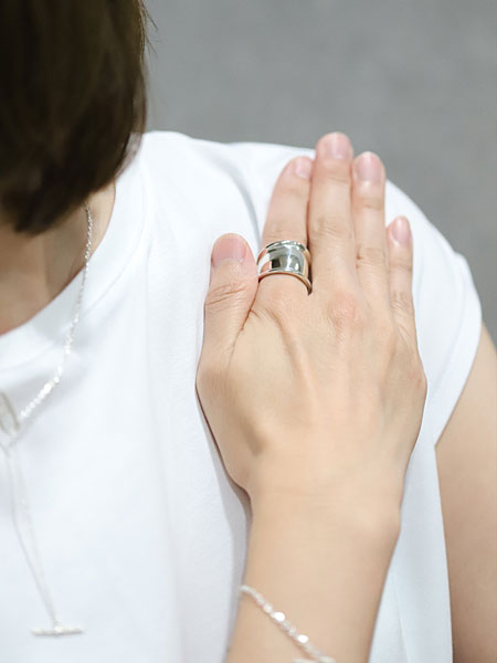 せり上がった縁のデザインが印象的で、シンプルながら存在感のある手元に仕上げた女性の着用画像。