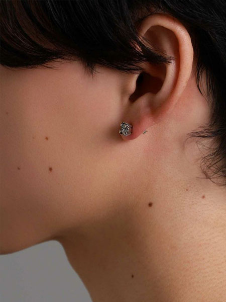 男性が横を向いた状態で着けているピアスを写した着用画像。