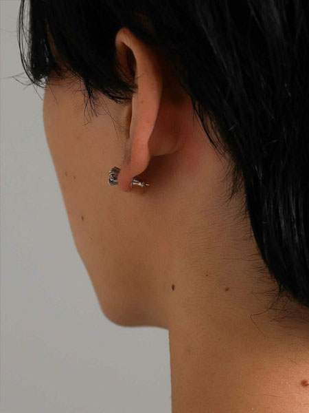 男性が着用した耳を斜め後ろから撮影し、キャッチとポストが見える写真。