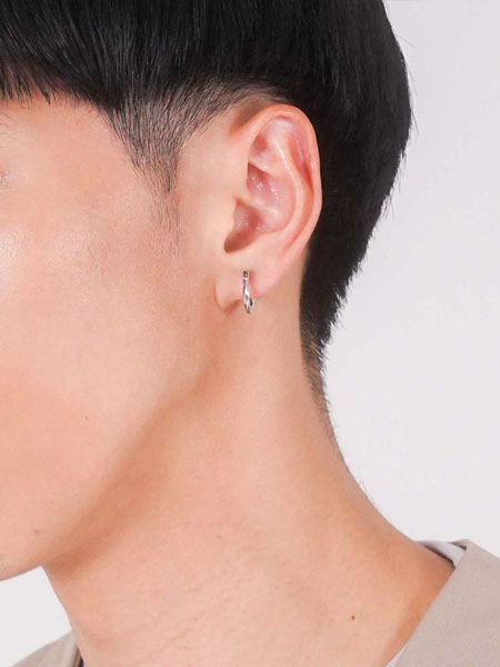 男性が横を向いた状態で、クロッシングピアスのMサイズを着用した耳元の画像。