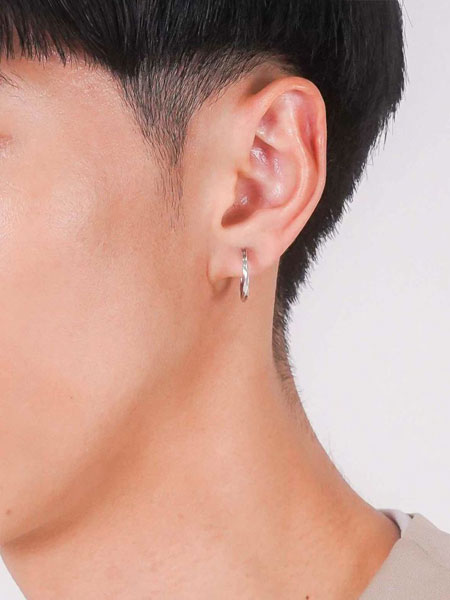 男性が横を向いた状態で、クロッシングピアスのLサイズを着用した耳元の画像。