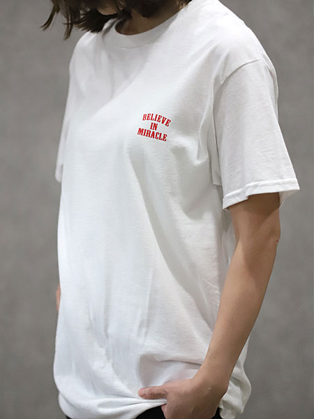 女性が着用したTシャツのフロント画像で、胸元のブランドロゴとホワイトを基調としたシンプルなデザインがわかります。