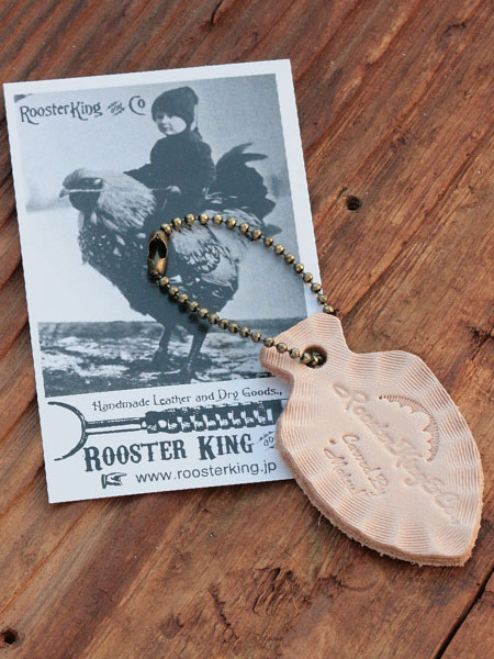 ネックレスに付属するRoosterKing&Co.のブランドカード＆レザータグを写した画像。