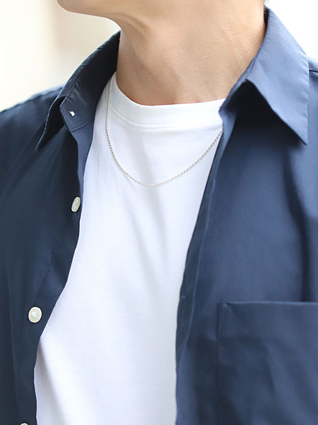 男性がロープ チェーン ネックレスを着用、程よい細さで首元に自然に馴染み、上品な印象を与えている。