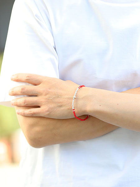 男性がSunkuのレッド ヴィンテージ ビーズ シルバー ピース フック ブレスレットを着用した正面画像、シンプルな服装に鮮やかなレッドがよく映える。