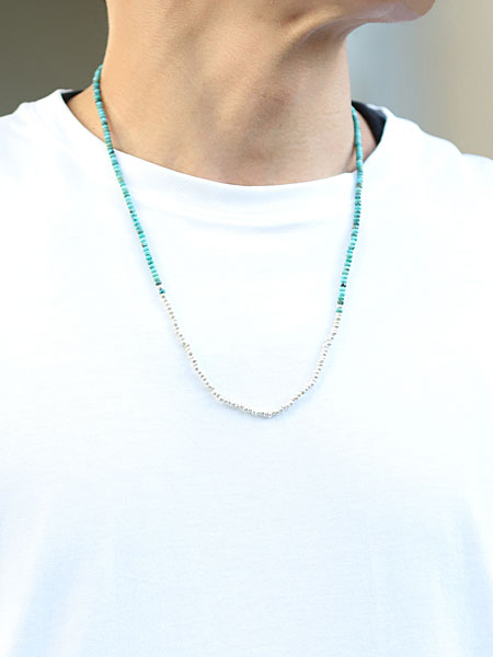 男性がターコイズネックレスを着用、細身ながらもしっかりと存在感があり、Tシャツスタイルにも映える。