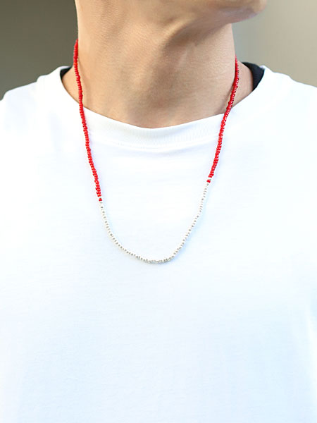 男性がレッド ビーズ ネックレスを着用、細身ながらもしっかりと存在感があり、Tシャツスタイルにも映える。