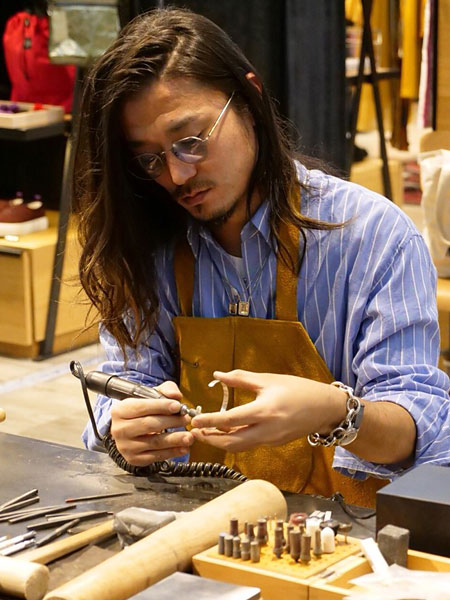 デザイナーがエスカプラーリオ ネックレスを着用して、アクセサリーを制作している様子。