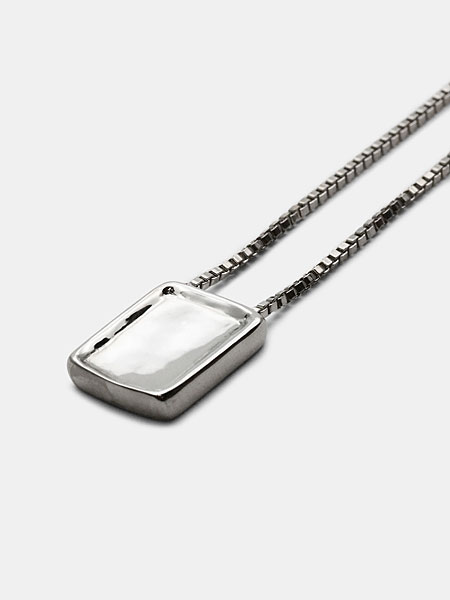 シルバーカラーのペンダントトップをアップで撮影した画像で、スクエア型の立体的な造形が印象的。