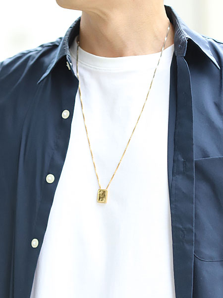 男性がゴールドカラー側を表にして着用したエスカプラーリオ ネックレスの着用画像。
