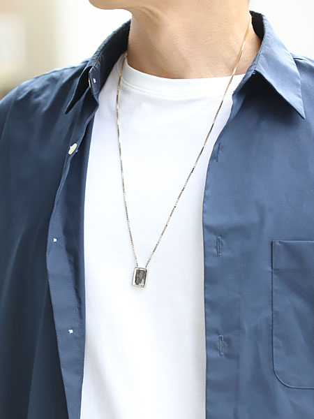 男性がシルバー側を表にして着用したエスカプラーリオ ネックレスの着用画像。