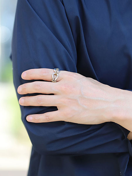 シャツスタイルの男性が、ホースウィスパラーリングを合わせた手元の写真。