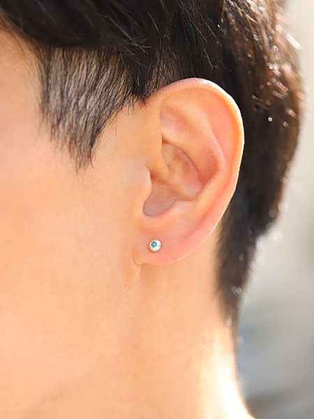 正面から見た男性の着用画像、さりげないサイズ感で、耳元に爽やかなアクセントを添えている。