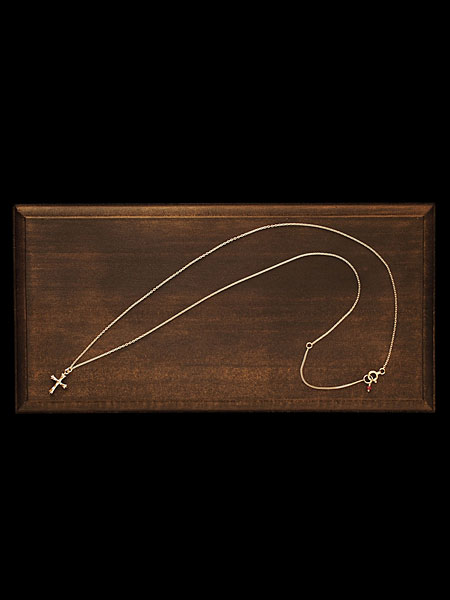 木箱の上にクロスネックレス全体を配置したイメージ。