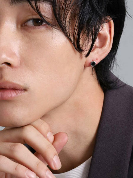 男性が正面からピアスを着用しており、コイン型のスタッズが自然に馴染んで見える画像。