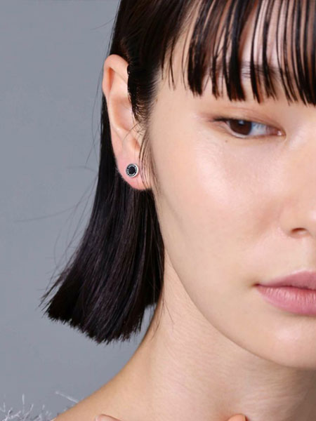 女性が正面からピアスを着用しており、スタッズのシンプルさが上品に映るフロントショット。