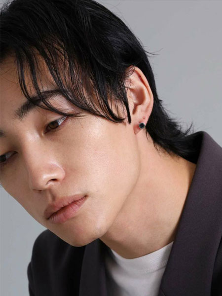 男性が正面からピアスを着用しており、コイン型のスタッズが自然に馴染んで見える画像。