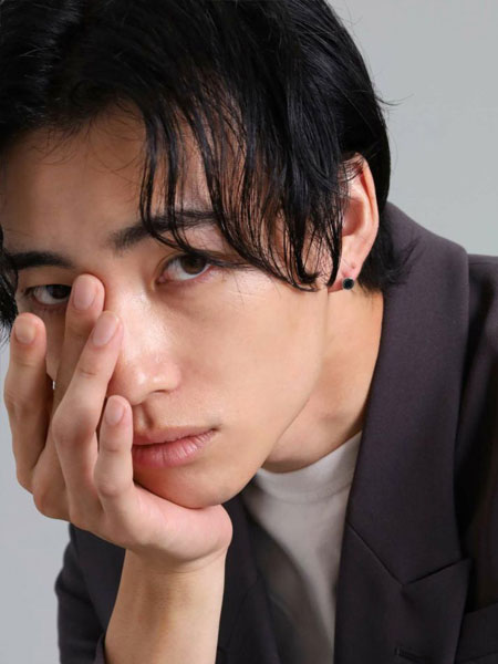 男性が正面からピアスを着用しており、コイン型のスタッズが自然に馴染んで見える画像。