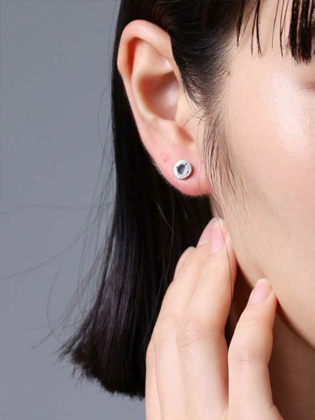 女性が正面からピアスを着用しており、スタッズのシンプルさが上品に映るフロントショット。