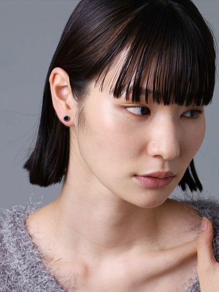 女性が正面からピアスを着用しており、スタッズのシンプルさが上品に映るフロントショット。