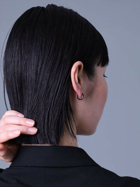 後ろから写した女性の着用写真で、フープの厚みや多面体の反射が控えめに見える自然な雰囲気の一枚。