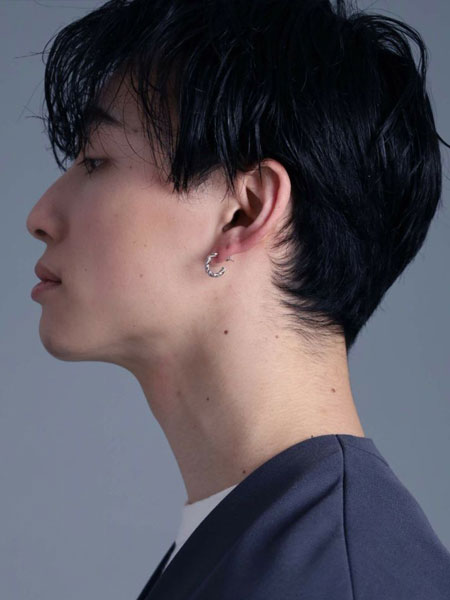 男性の横顔を写した写真で、ピアスのG型ラインとツイストの陰影がよく見える一枚。