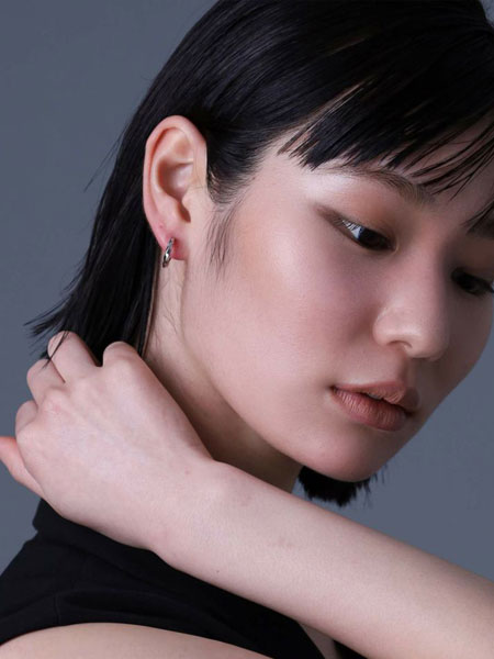 女性を斜め前から撮影し、ツイストの反射が控えめに輝く上品な雰囲気が伝わる写真。