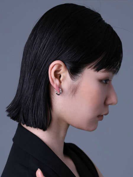 女性の横顔を写した写真で、ツイストのラインが耳元に自然な動きを生む様子がわかる一枚。