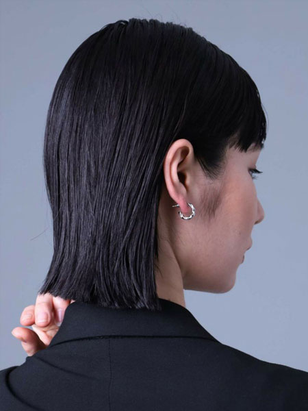 女性を後ろから撮影し、ピアスが控えめに光る自然な着用イメージが伝わる写真。