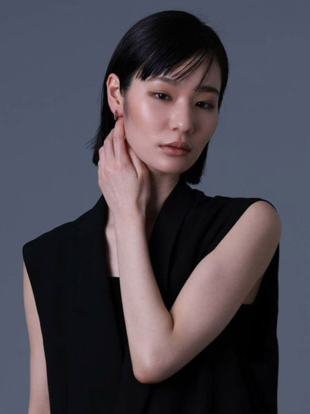 女性がピアスを着用した、シンプルなツイストデザインが自然に馴染んでいる様子がわかる正面から写した写真。