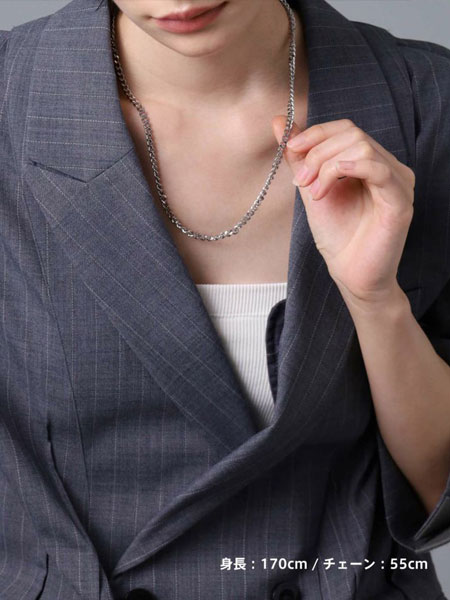 女性がチェーンを軽く持ち上げて、デザインを見せている着用シーン。