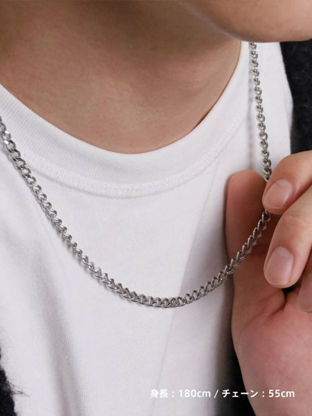 男性がチェーンを軽く持ち上げて、デザインを見せている着用シーン。