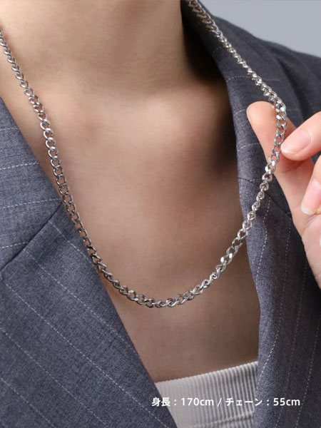 女性がチェーンを軽く持ち上げて、デザインを見せている着用シーン。