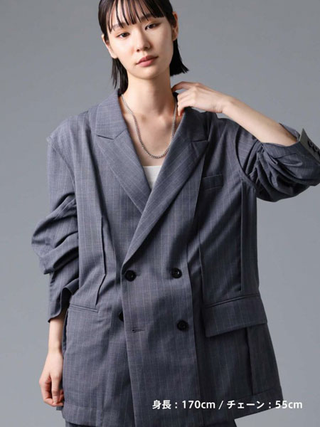 女性の全体シルエットと共に、ネックレスの合わせやすさが伝わる遠めの画像。