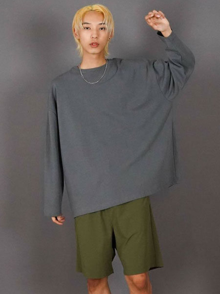 男性の全体コーデの中でネックレスの雰囲気が伝わる、少し距離を取った画像。