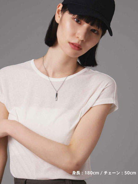 女性がネックレスを着用した姿を正面から写しており、ユニセックスデザインが性別問わず取り入れやすいことが伝わる。