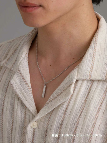 男性がネックレスを着用した姿を斜め前から写しており、プレートのさりげない光がスタイルにアクセントを添えている。