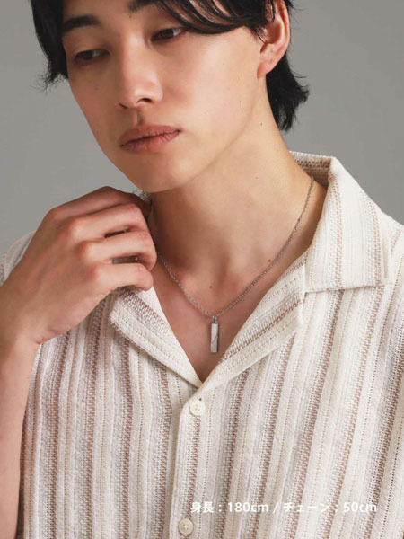 男性がネックレスを着用した姿を正面から写しており、シンプルな服装に自然と馴染むプレートデザインのバランスがよく分かる。