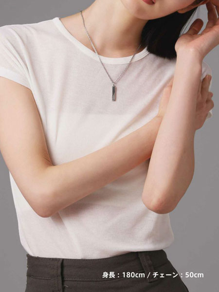 女性がネックレスを着用した姿を正面から写した別カットで、シンプルなトップが首元で上品に映える様子が伝わる。