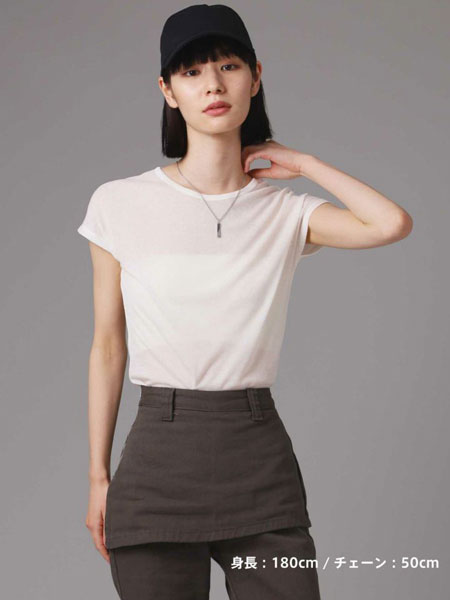 女性を遠めから撮影した画像で、ネックレスがコーデ全体のアクセントとして控えめに輝いている。