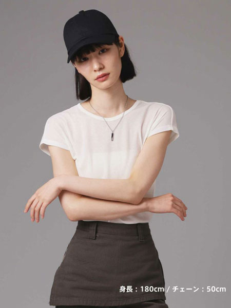 女性を遠めから撮影した画像で、ネックレスがコーデ全体のアクセントとして控えめに輝いている。